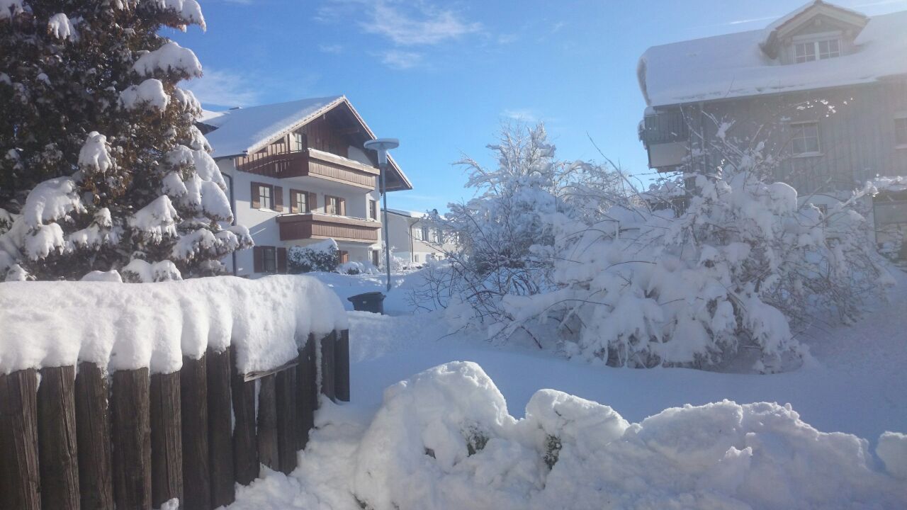 Großer Garten mit Terasse mit sehr viel Schnee bedeckt bei sonnigem Wetter und blauem Himmel