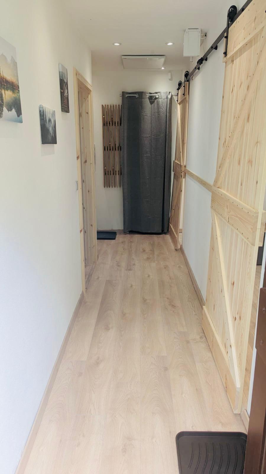 Länglicher Flur mit Fichtenholz Schiebetüren und einer Garderobe und Abstellkammer am Ende des Flurs