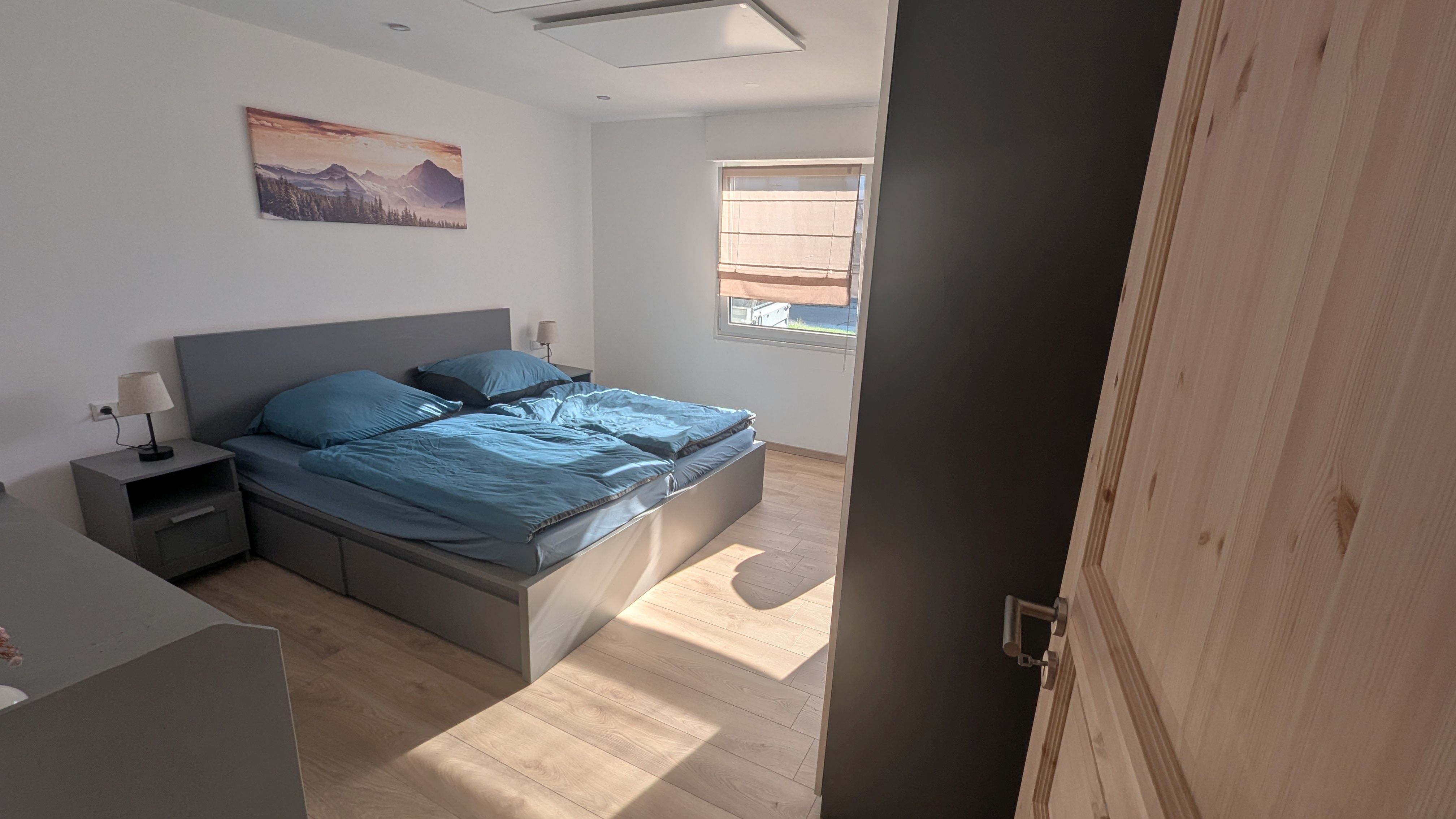 Schlafzimmer mit doppelbett und Nachttischen und Nachttischlampen in einer Ferienwohnung.